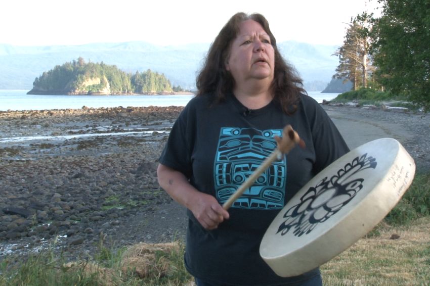 Indigenous woman playing drum